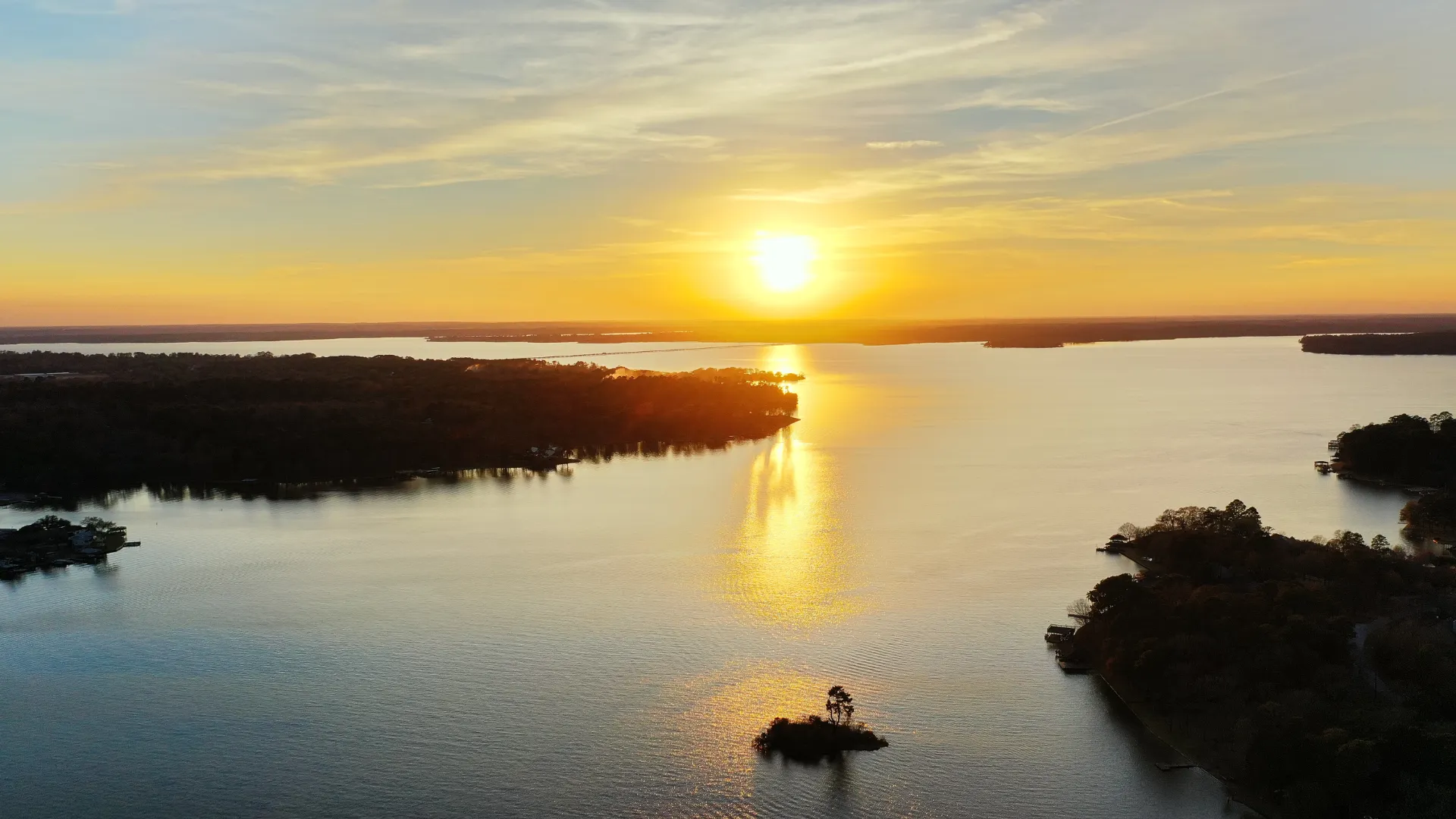 Image of small islands on Lake Conroe with sunset in the distance