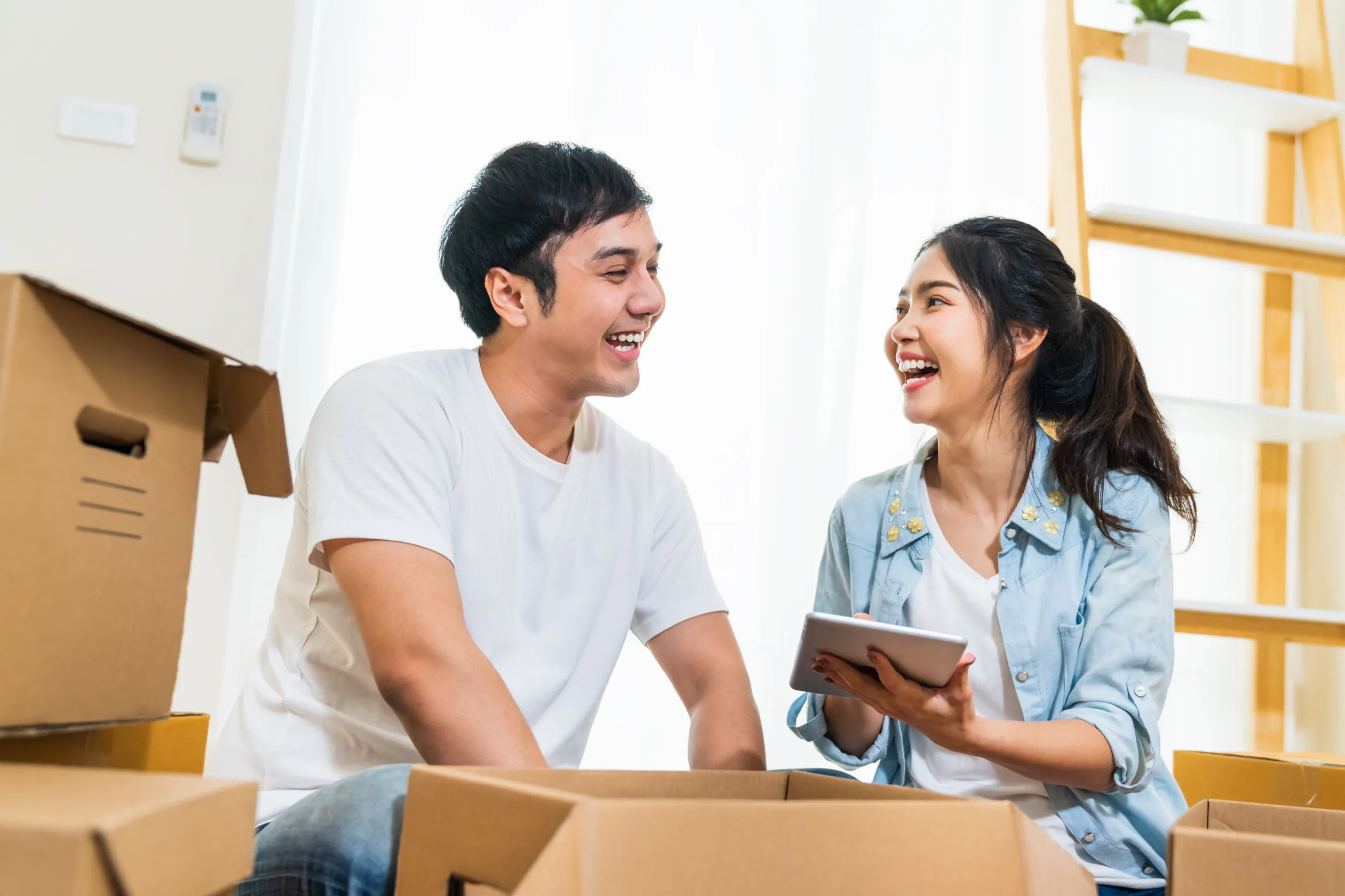 Young Asian couple packing boxes at home