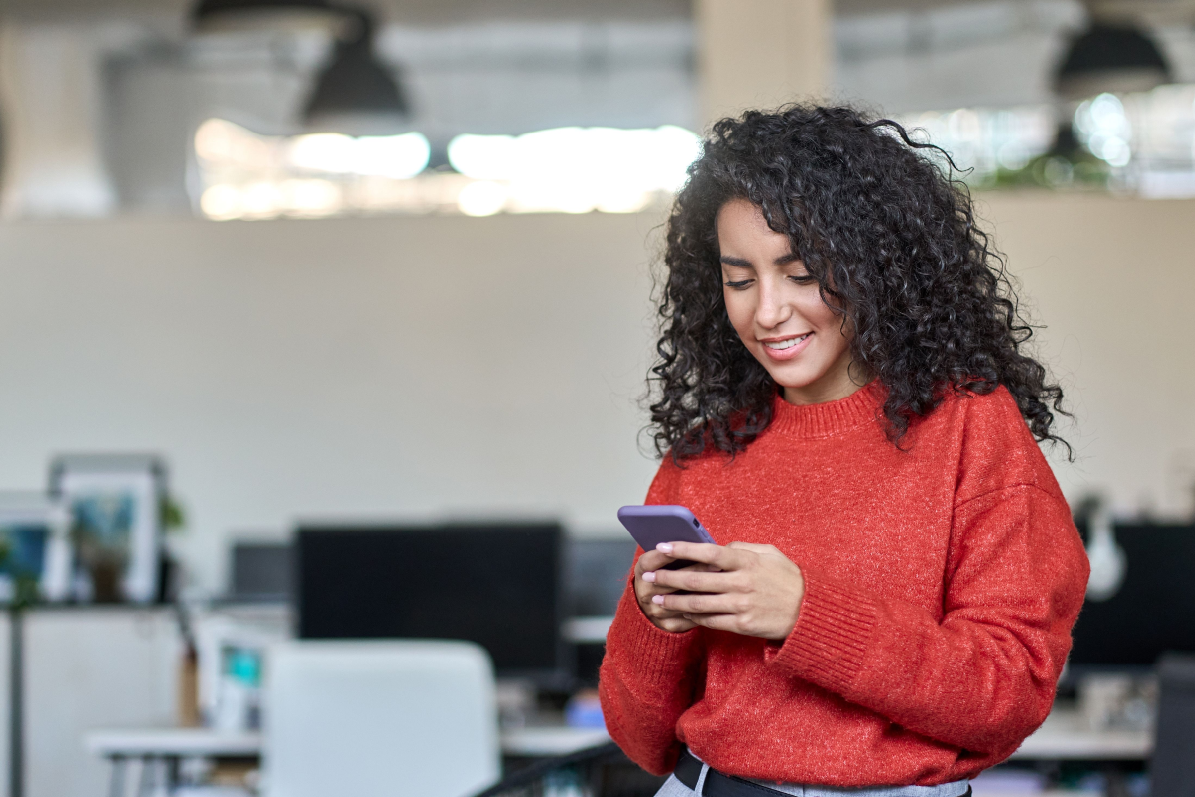 Woman looking at phone in office