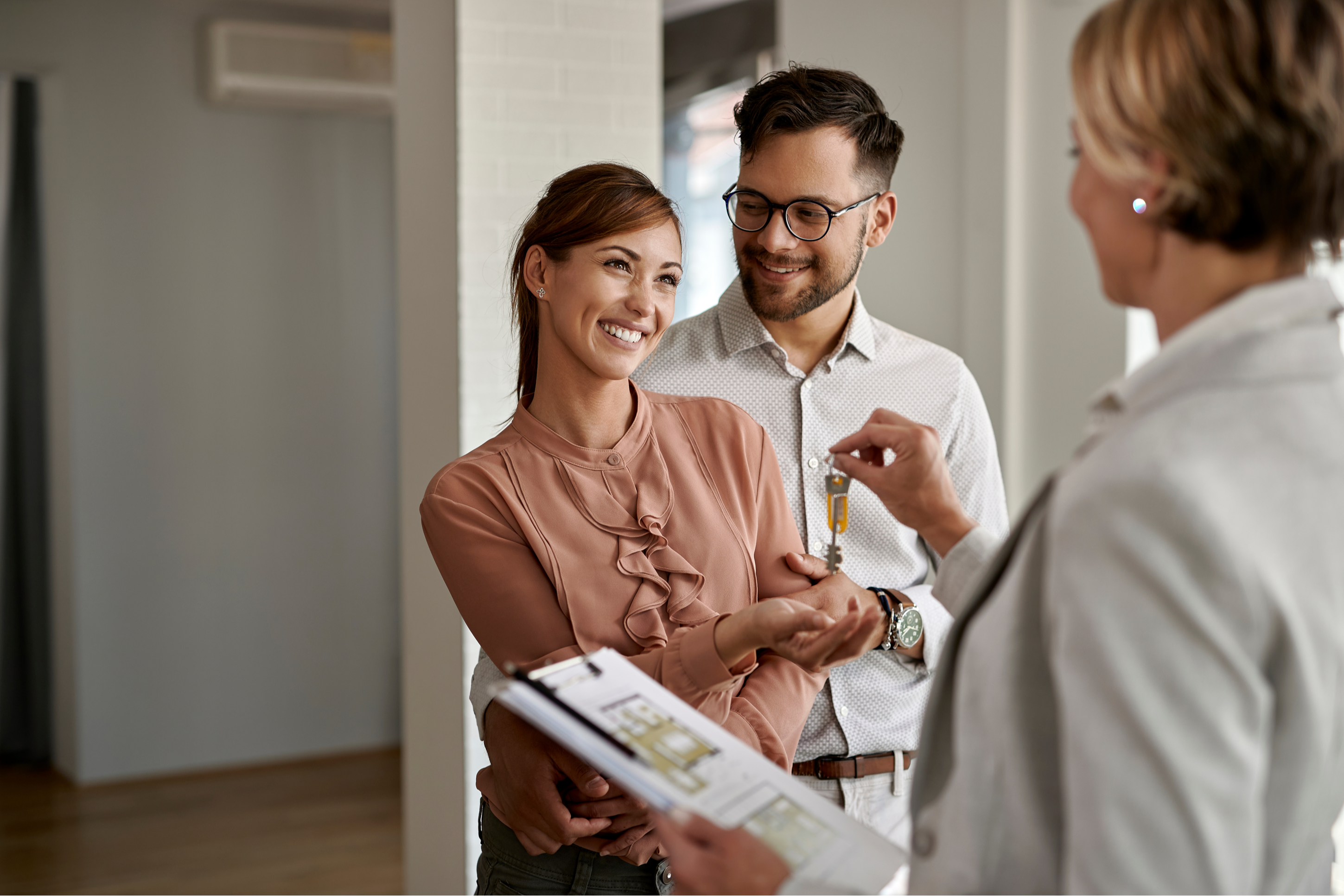 Young couple accepting keys to home from REALTOR